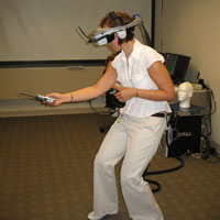 A lab member demonstrates virtual reality gear worn by study participants.