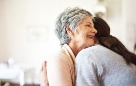 Shot of a senior woman hugging a young woman in a retirement home
