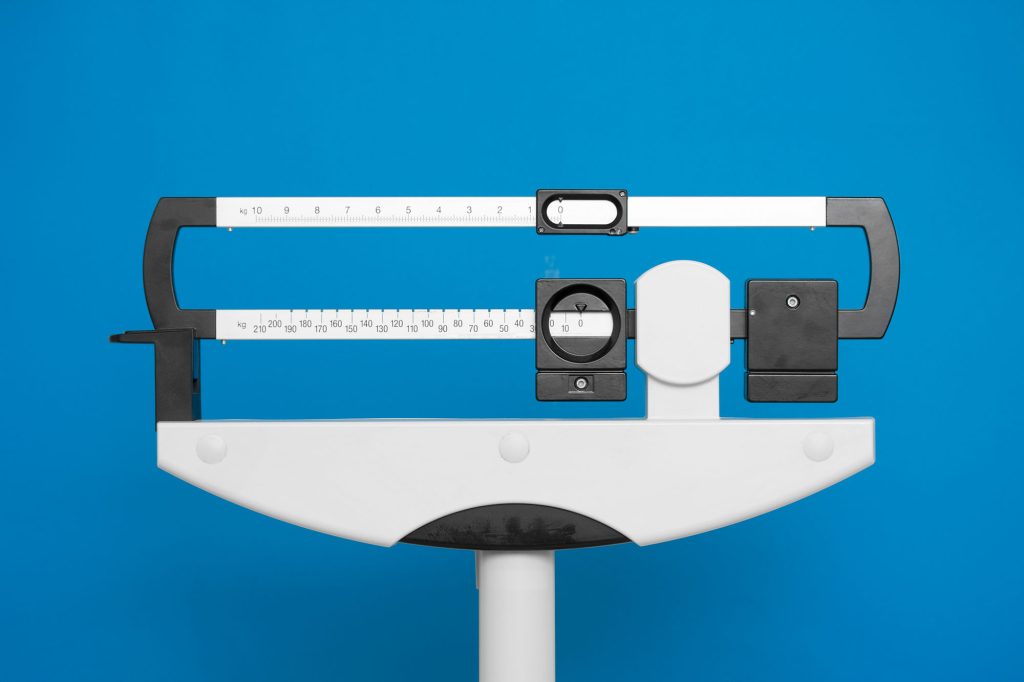 Medical weight scale on a blue background.