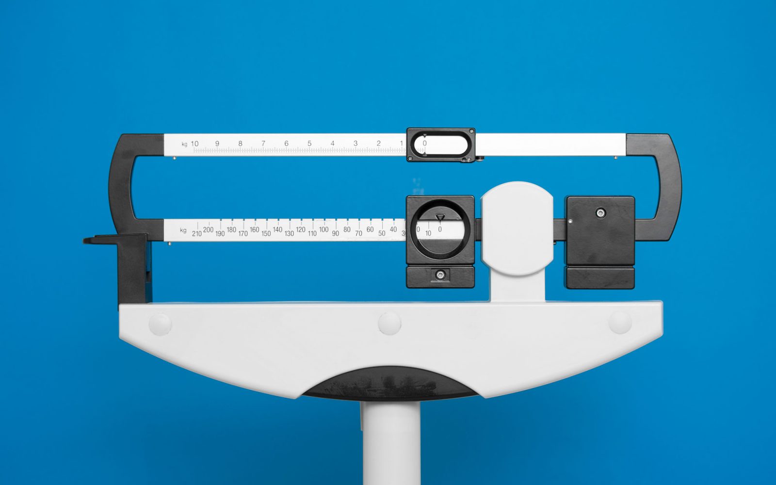 Medical weight scale on a blue background.