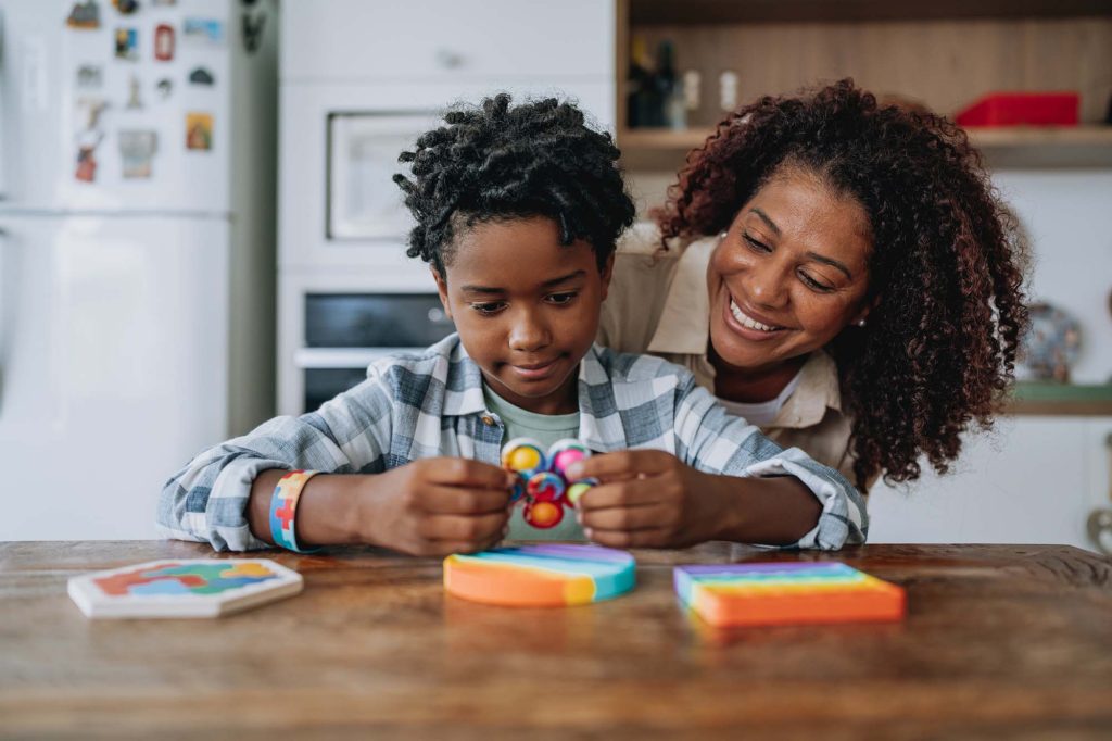 A mother and child play with toys on a kitchen counter.