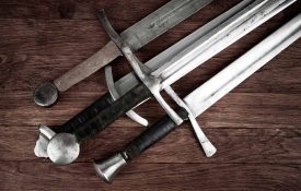 Four swords on a wooden background.